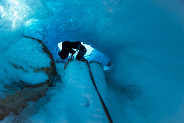 Ein Eiskletterer in einem Eistunnel