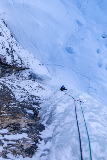 Eine Person beim Eisklettern.