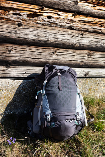 Gregorgy Maven 55 Wanderrucksack lehnt an H&uuml;ttenwand in der Sonne