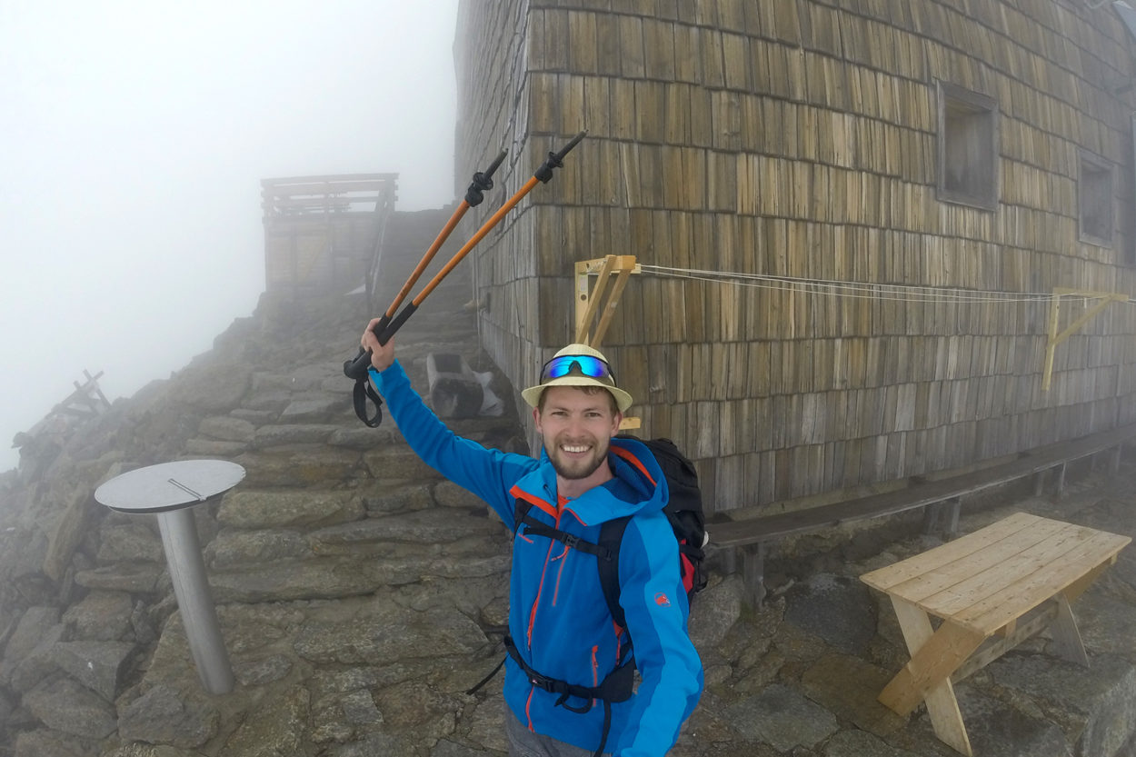Ein fr&ouml;hlicher Bergsteiger im Nebel vor dem Becherhaus.