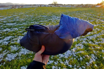 Die Icebreaker Hyperia Lite Hybrid Jacke verstaut in ihrer Innentasche.