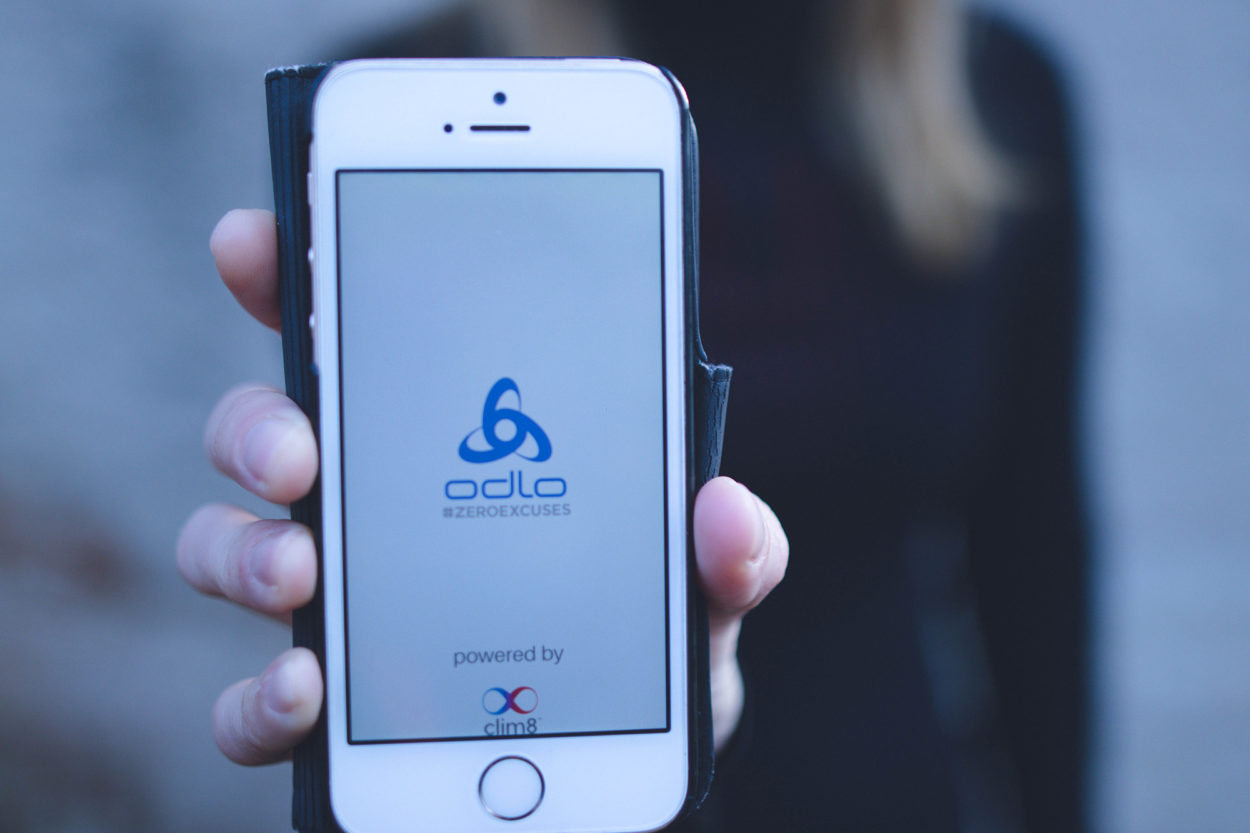 Frau h&auml;lt Smartphone in die Kamera mit Odlo App